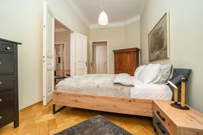 a bedroom with a large bed and a dresser at Large and modern apartment in the heart of Prague in Prague