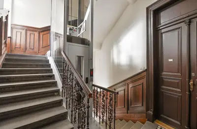 a hallway with stairs and a wooden door at Large and modern apartment in the heart of Prague in Prague