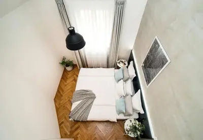 a small attic bedroom with a bed and a window at Large and modern apartment in the heart of Prague in Prague