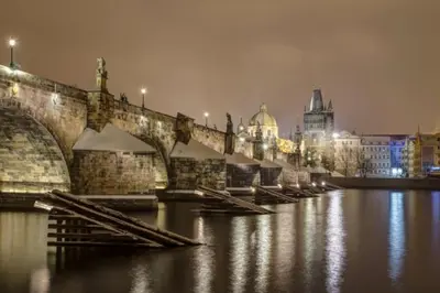a bridge over a river with a city at night at Large and modern apartment in the heart of Prague in Prague