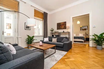 a living room with two couches and a table at Large and modern apartment in the heart of Prague in Prague