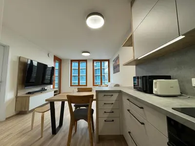 a kitchen with a dining table and a microwave at Smíchov City apartment - Albrigtova in Prague