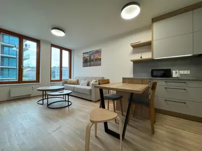 a kitchen and living room with a table and chairs at Smíchov City apartment - Albrigtova in Prague