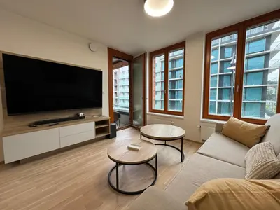 a living room with a couch and a flat screen tv at Smíchov City apartment - Albrigtova in Prague