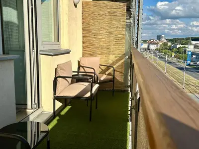 two chairs and a table on the balcony of a building at Apartment Českomoravská - O2 Arena Prague in Prague
