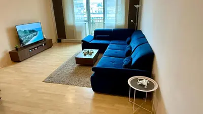 a living room with a blue couch and a tv at Apartment Českomoravská - O2 Arena Prague in Prague