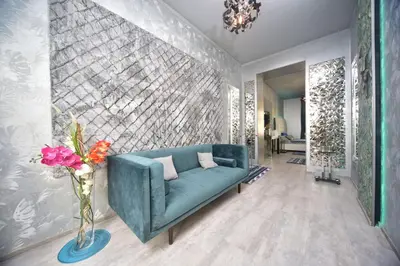 a living room with a blue couch and flowers in a vase at TF Wellness in Prague