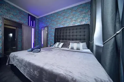 a bedroom with a large bed with purple lighting at TF Wellness in Prague