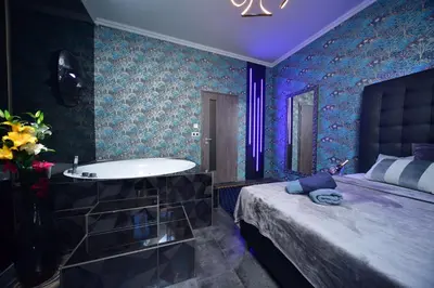 a bathroom with a tub and a bed and a sink at TF Wellness in Prague