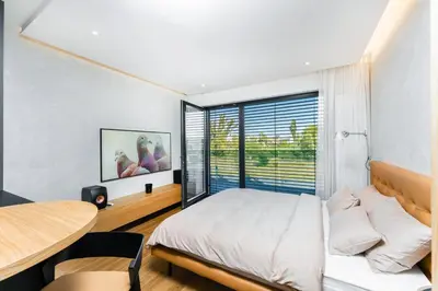a bedroom with a bed and a table and a window at Manažerské bydlení - ROHAN CITY in Prague