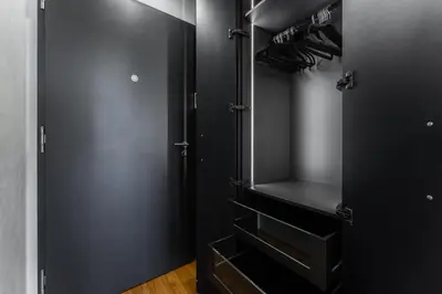 a walk in closet with black doors and wooden floors at Manažerské bydlení - ROHAN CITY in Prague