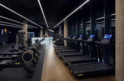 a gym with rows of tread machines and computers at Manažerské bydlení - ROHAN CITY in Prague