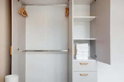 a closet with white shelves and a refrigerator at Blueground Holešovice family-friendly nr park PRG-3 in Prague