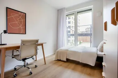 a bedroom with a bed and a desk and a window at Blueground Holešovice family-friendly nr park PRG-3 in Prague