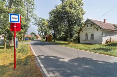 a street with a sign in front of a house at Fara Bošín in Křinec