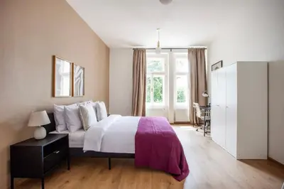 a bedroom with a large bed and a window at Blueground - Vrsovice, furnished in Prague