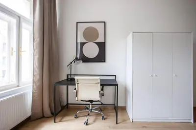 a desk with a chair and a lamp in a room at Blueground - Vrsovice, furnished in Prague