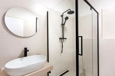 a white bathroom with a sink and a mirror at Blueground - Vrsovice, furnished in Prague