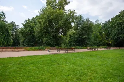 a row of benches sitting in a park at Blueground - Vrsovice, furnished in Prague