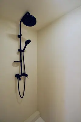 a shower in a corner of a room at Ztracený Sad - Glamping na samotě in Nečín