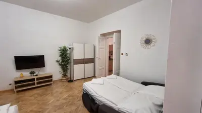 a white bedroom with a bed and a television at Apartment Krakovska 20 in Prague