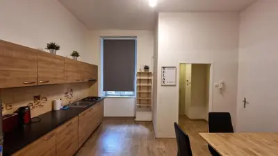 a kitchen with wooden cabinets and a table and a counter top at Apartment Krakovska 20 in Prague