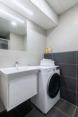 a bathroom with a washing machine and a sink at Central Tiny Flat, 1GB WiFi, SMART TV, Air Condition in Prague