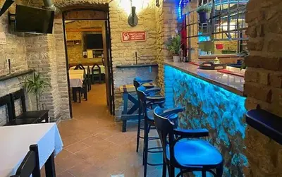 a bar with blue stools in a restaurant at Alba Hostel in Prague