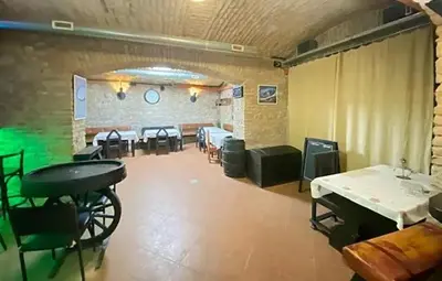a large room with tables and chairs and a room with a table at Alba Hostel in Prague