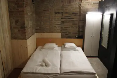 a large bed in a room with a brick wall at Alba Hostel in Prague