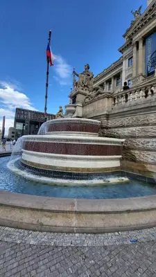 a fountain in front of a building with a flag at Alba Hostel in Prague