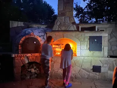 two people standing in front of an oven at night at Biotop Kotlyk in Netvořice