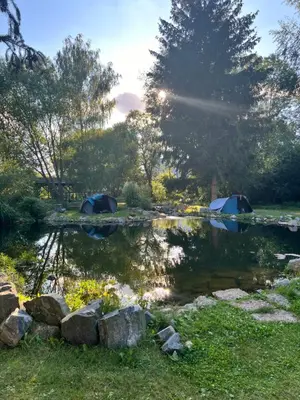 a pond with two tents in a park at Biotop Kotlyk in Netvořice