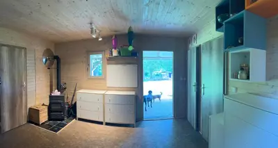 a room with a kitchen with a dog standing in the doorway at Biotop Kotlyk in Netvořice