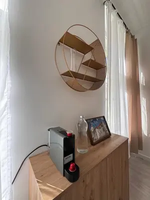 a mirror on a wall next to a table with a clock at Arbes 13 - Sweet Home in Prague