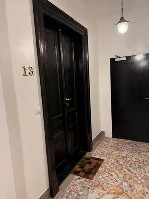 a black door in a room with a tile floor at Arbes 13 - Sweet Home in Prague