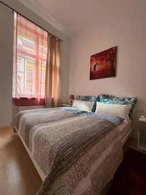a bedroom with a large bed and a window at Arbes 13 - Sweet Home in Prague