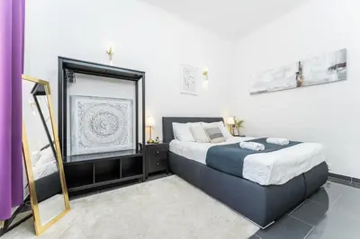 a bedroom with a large bed and a mirror at Rentero Apartment, 10 minutes Wenceslas Square, Prague in Prague