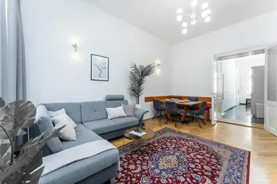 a living room with a blue couch and a table at Rentero Apartment, 10 minutes Wenceslas Square, Prague in Prague