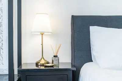 a lamp on a table next to a bed at Rentero Apartment, 10 minutes Wenceslas Square, Prague in Prague