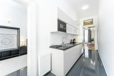 a white kitchen with a sink and a microwave at Rentero Apartment, 10 minutes Wenceslas Square, Prague in Prague