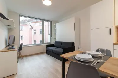 a living room with a dining table and a couch at SMART Studio with Ultra Fast 1Gbps WiFi and Air Conditioning in Prague