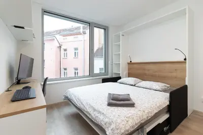 a bedroom with a bed and a desk with a computer at SMART Studio with Ultra Fast 1Gbps WiFi and Air Conditioning in Prague