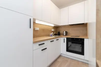 a white kitchen with white cabinets and a sink at SMART Studio with Ultra Fast 1Gbps WiFi and Air Conditioning in Prague