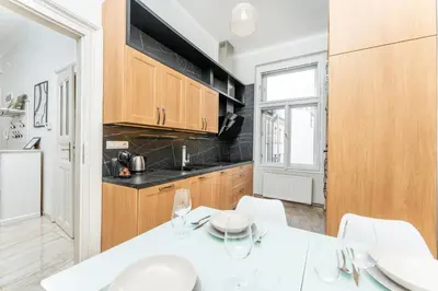 a kitchen with a white table and white chairs at Rentero Friendly Apartment near Wenceslas Square in Prague