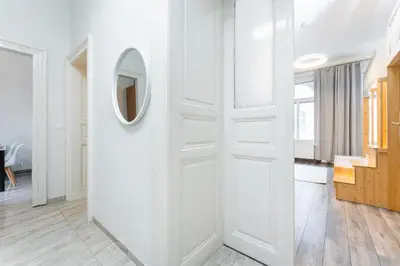 a hallway with white walls and a mirror on a wall at Rentero Friendly Apartment near Wenceslas Square in Prague