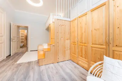 a large room with wooden cabinets and a staircase at Rentero Friendly Apartment near Wenceslas Square in Prague