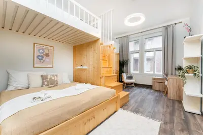 a bedroom with a large bed with a loft at Rentero Friendly Apartment near Wenceslas Square in Prague