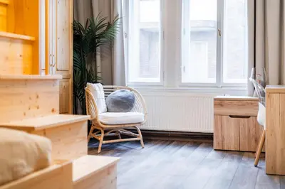 a chair with a pillow on it in a room with a window at Rentero Friendly Apartment near Wenceslas Square in Prague