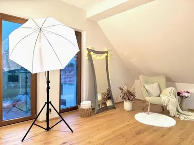 a tripod in a room with a white umbrella and a chair at STUDIO KRÁLOVICE Apartment in Prague